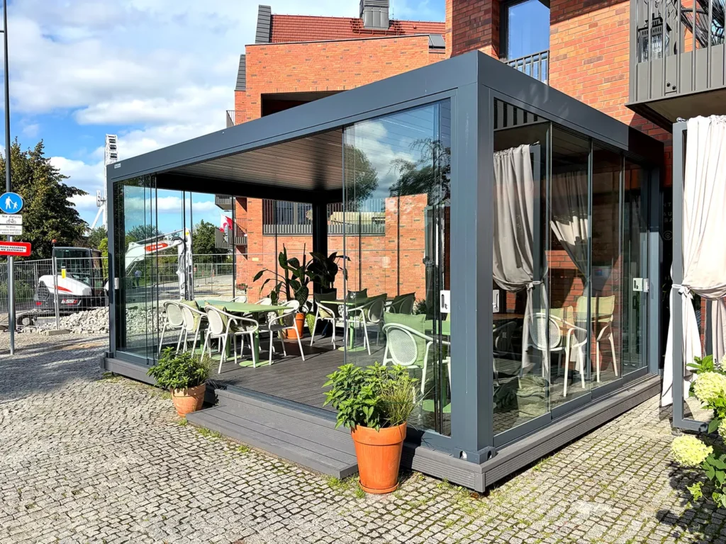 Pergola dla restauracji Content w Gdańsku - aluminiowa konstrukcja LUX 6×4 w kolorze antracytowym z zabudową szklaną, stoliki wewnątrz