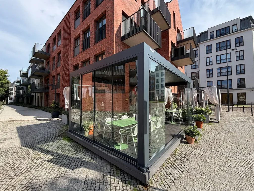 Pergola gastronomiczna 6×4 m w Gdańsku widziana od ulicy - szklane drzwi przesuwne i podest kompozytowy