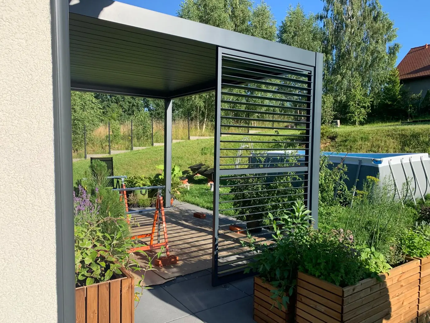 Pergola tarasowa 3×3 w Otominie - widok na taras spod dachu lamelowego